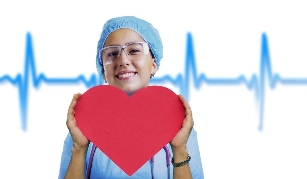 A nurse holding a heart. Nurses are caring and have a heart for taking care of others. We appreciate you