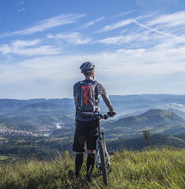 A biker's view from top of a mountain overlooking the city and other mountains
